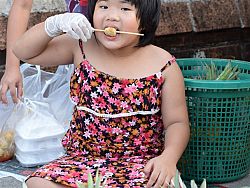 A girl snacks at the Friday market