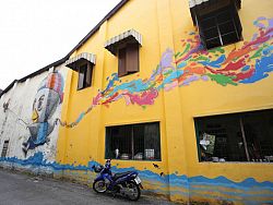 Painted by Mue Bon, this colourful bird adorns the side of a local restaurant on Phang Nga Road