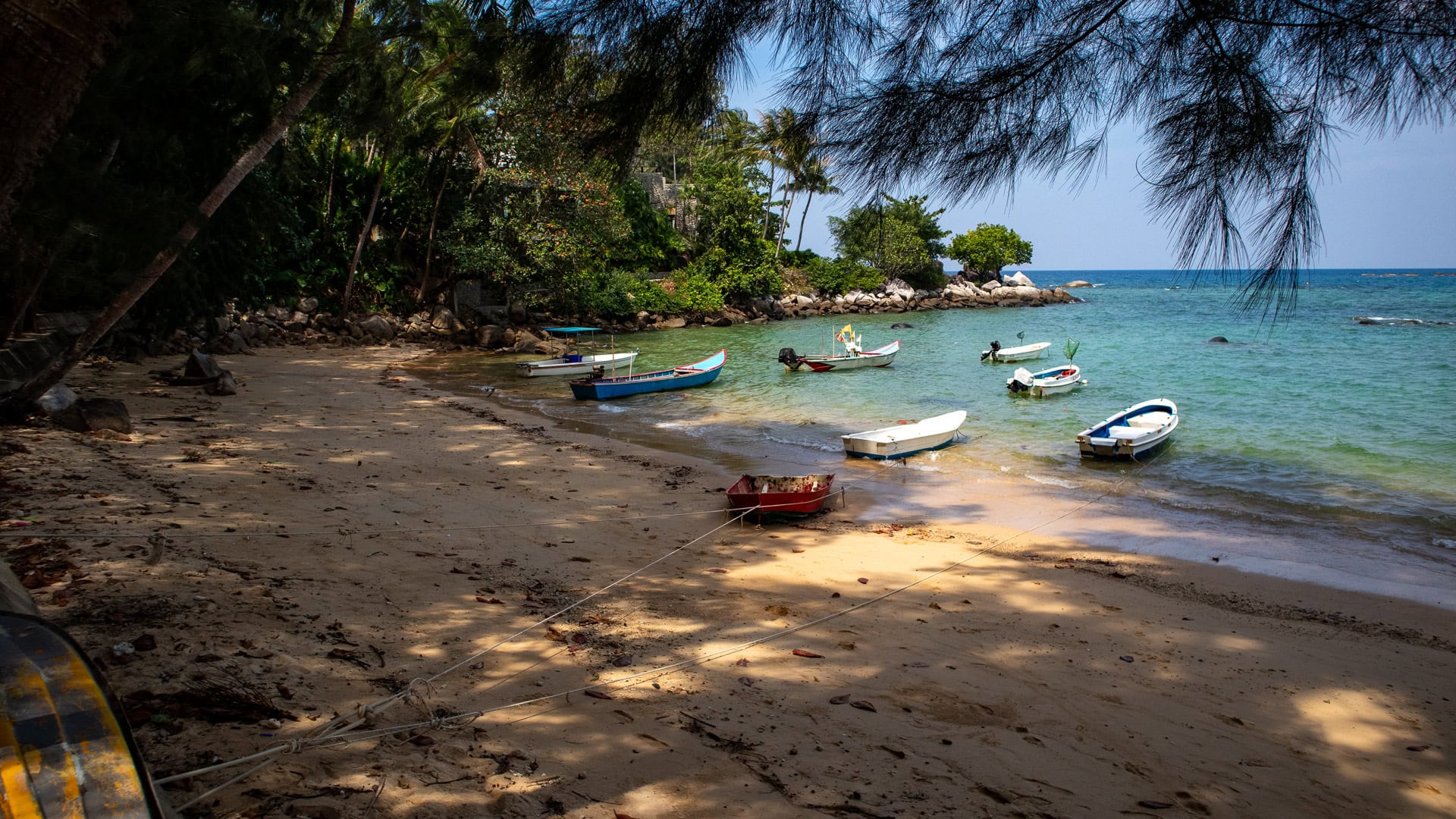 Hua Beach Phuket quiet sandy beach with tree shade and rocky edges