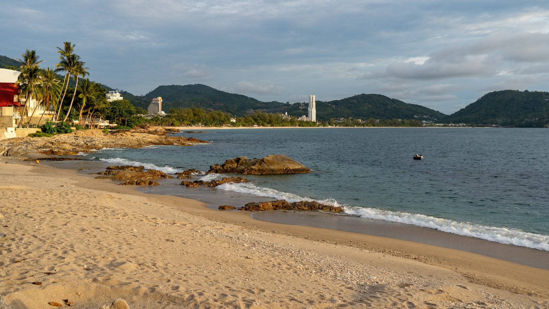 Kalim Beach Phuket rocky cove with shallow water and people wading