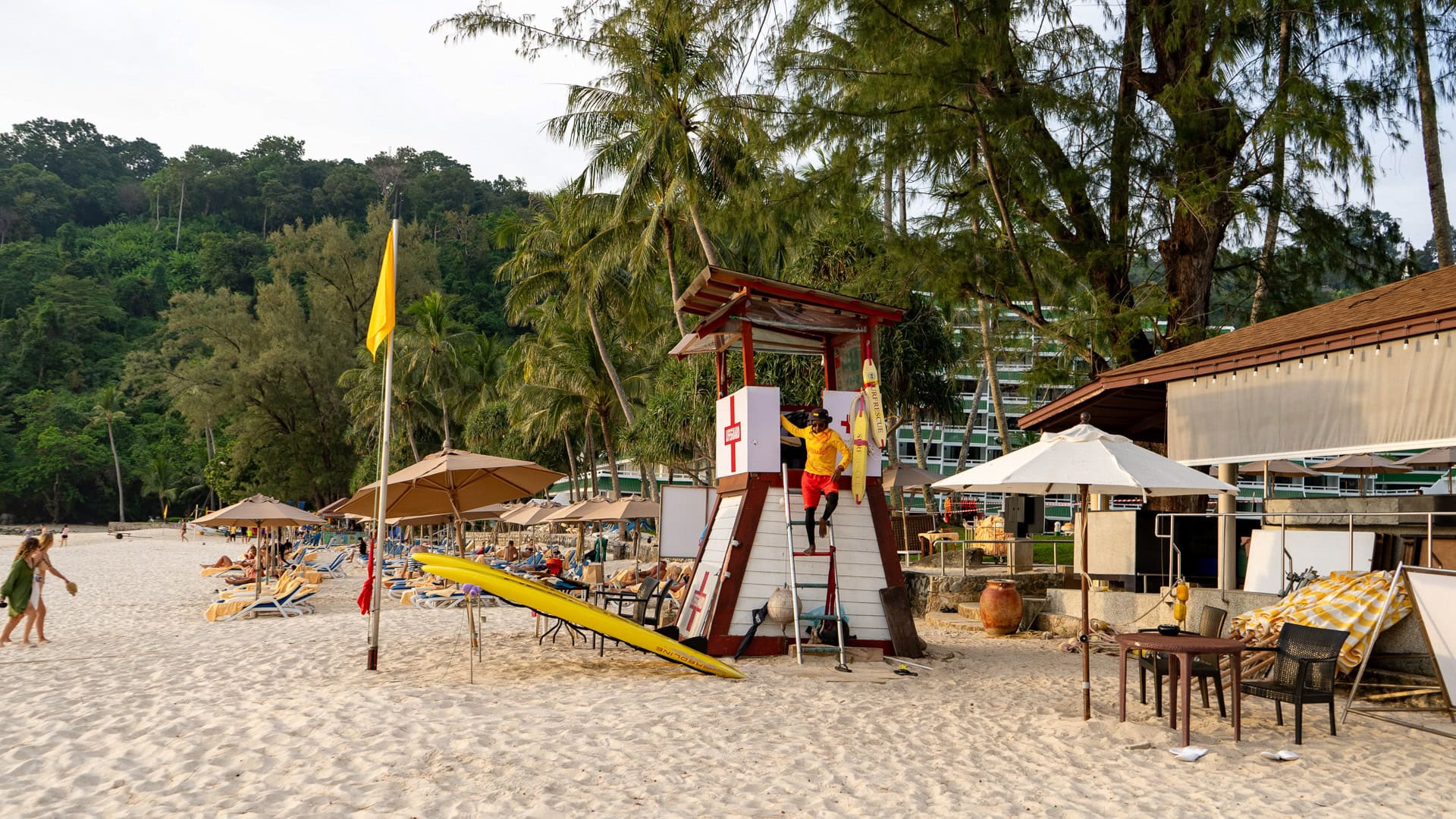 Karon Noi Beach Phuket lifeguard tower with rescue equipment, sun loungers, and palm trees along the beach