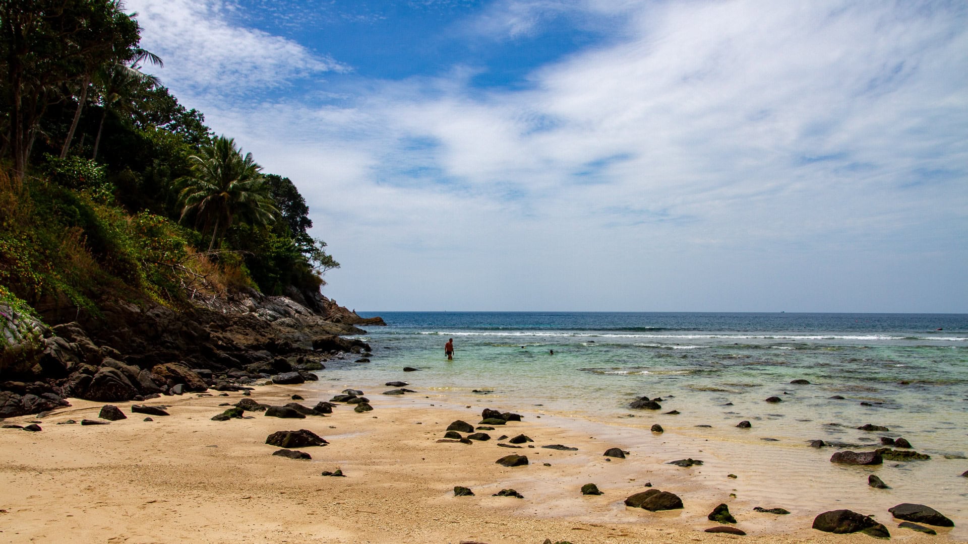 Merlin Beach Phuket with exposed rocks at low tide and calm sea
