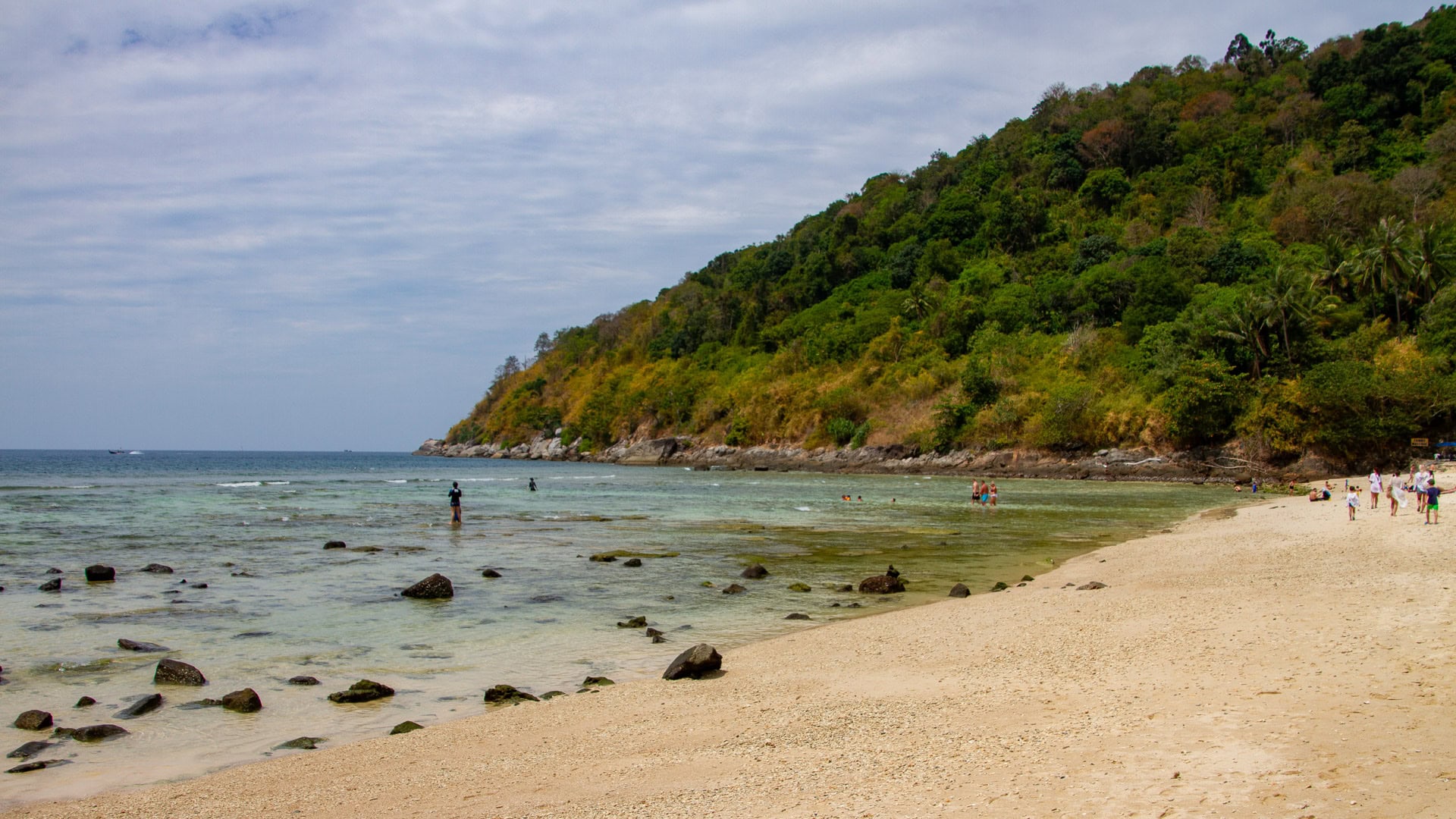 Merlin Beach Phuket shoreline with people walking and shallow reef area